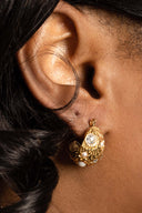 Model wearing chunky 18K gold-plated sculpted hoop earrings with pearl accents.