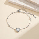Flat lay of the Statement Heart Beaded Anklet in silver on a neutral background.