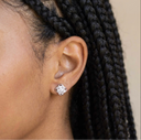 Close-up of an ear wearing a diamond earring with braided hair.