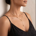 A close-up of a woman wearing Akuba Teardrop Necklace | Premium Stainless Steel paired with a black lace camisole top.