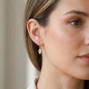 Oak Leaf Drop Earrings – 925 Sterling Silver- Close-up of a woman wearing gold earrings with a neutral background