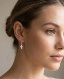 Oak Leaf Drop Earrings – 925 Sterling Silver -Close-up of a woman wearing a silver leaf-shaped earring against a neutral background