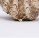 Mini CZ Necklace – Gold PVD Plated Stainless Steel. Gold necklace with a diamond pendant on a stone background