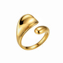 A polished gold-toned open ring with a smooth, organic, wavy silhouette, shown on a solid white background.
