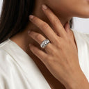 Sculpt Statement Ring- A close-up of a model's hand wearing a wide, textured silver ring, set against a white satin top and a neutral light background.