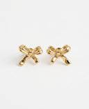 A pair of gold bow-shaped stud earrings on a clean, light off-white background.
