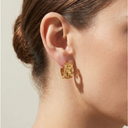 Gold hoop earring worn by a person with a neutral background