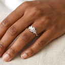Silver leaf ring on a person's finger with a neutral background