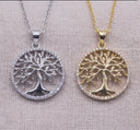 Two circular tree-of-life pendant necklaces displayed side by side on a textured beige fabric background. The left pendant is silver with a silver chain, and the right pendant is gold with a gold chain.