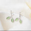 Nature-inspired opal stud earrings on white background
