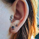 16g Dainty Flat-Back Snake Earrings showcasing a sleek snake design on an ear with a stud earring.